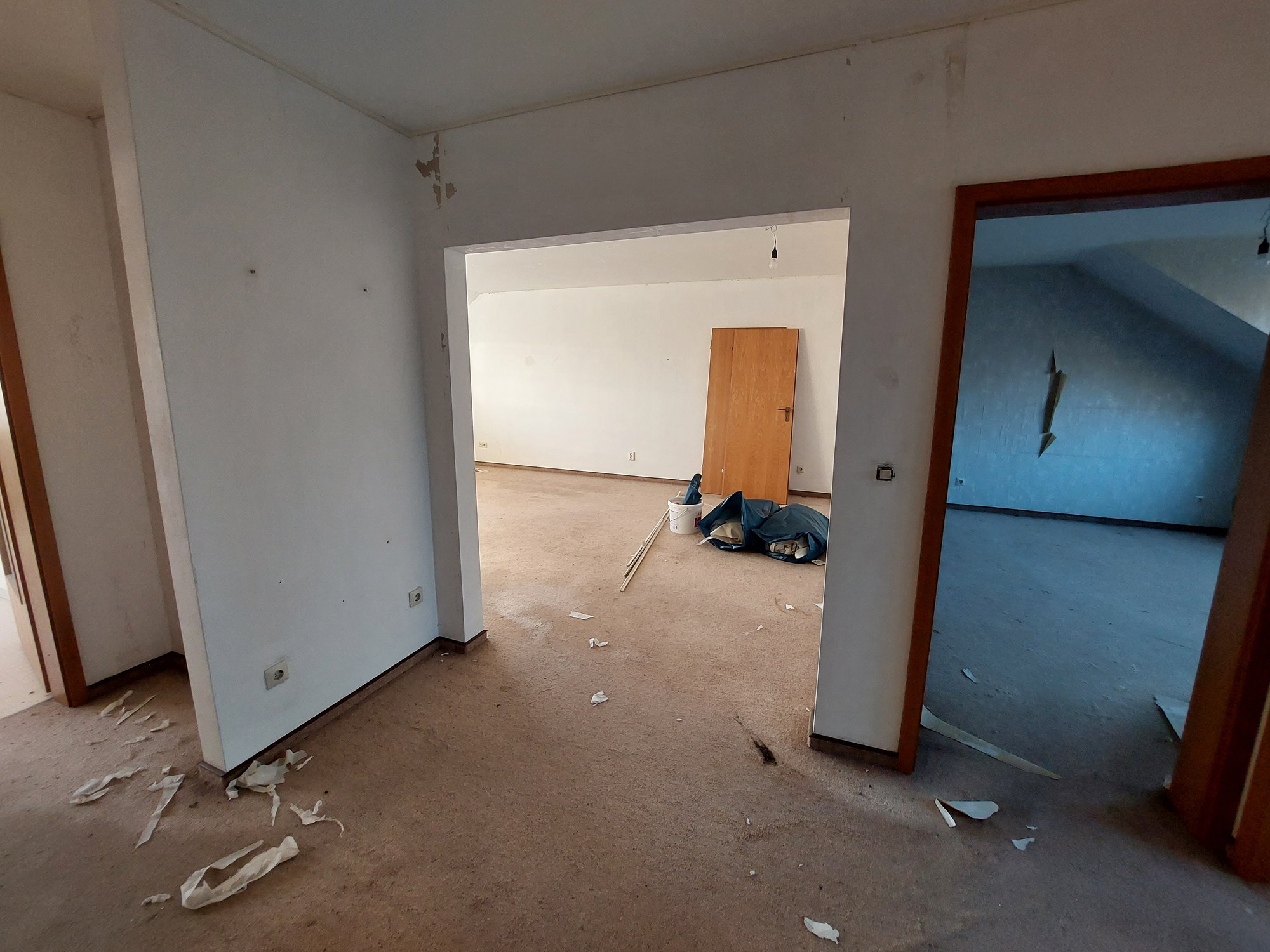 Flur vor der Renovierung mit Gebrauchsspuren an den Wänden und altem Bodenbelag
