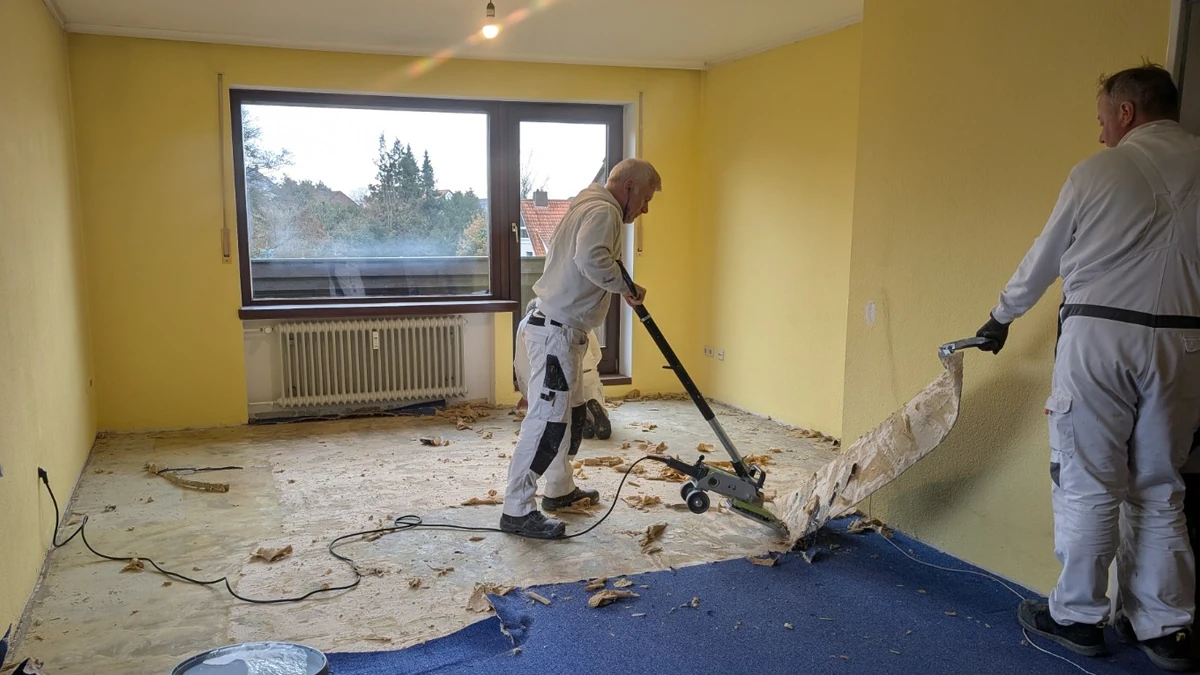 Alter Teppichboden wird mit einem Teppichstripper entfernt