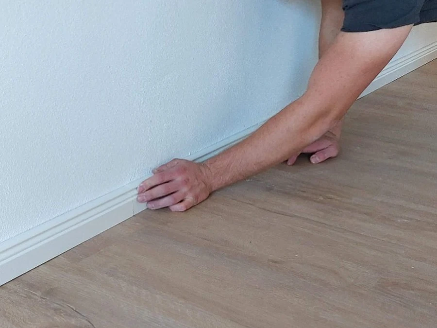 Detailarbeit beim Abschluss eines neu verlegten Bodenbelags