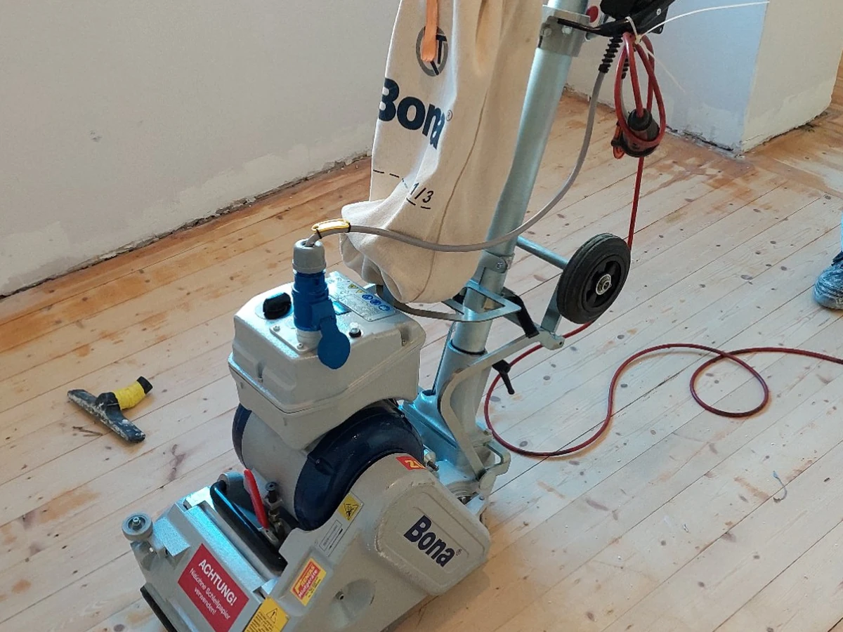 Bestehender Holzboden bei der Aufarbeitung mit einer Bodenschleifmaschine
