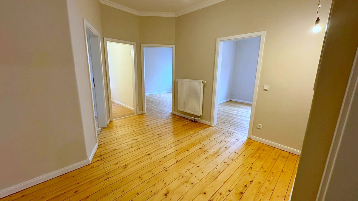 Renovierter Altbauflur mit Holzdielen und gestrichenen Wandflächen